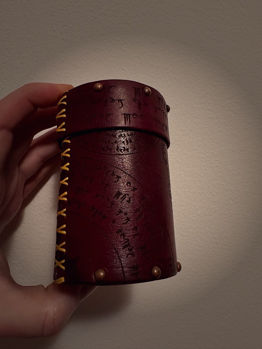 Side view of the Arcana leather cup with hand-stitched gold lacing detail